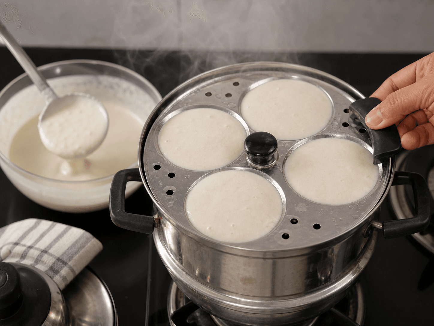 Mallige idli batter poured into greased idli moulds for steaming